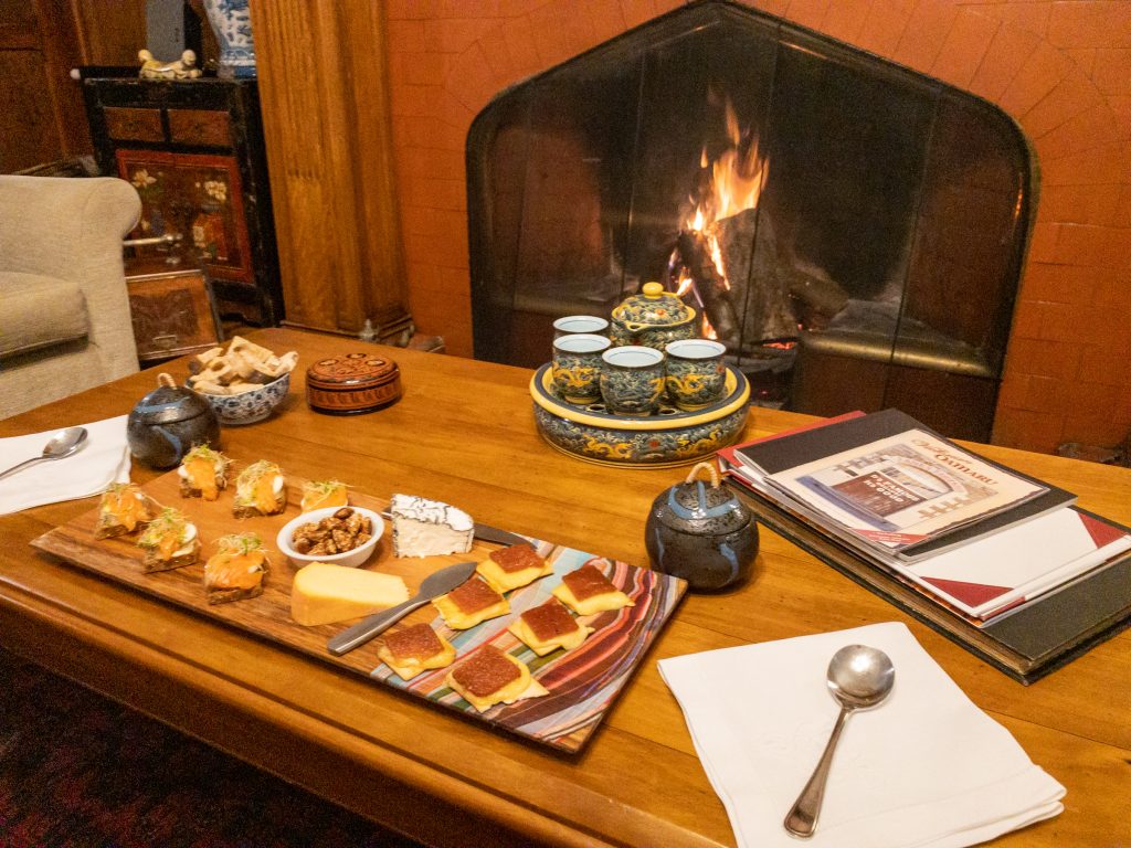 Roaring fire in the drawing room with a plate of canapés